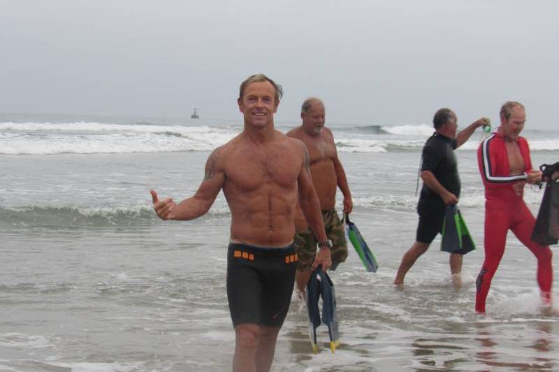 People with snorkels and fins on shore