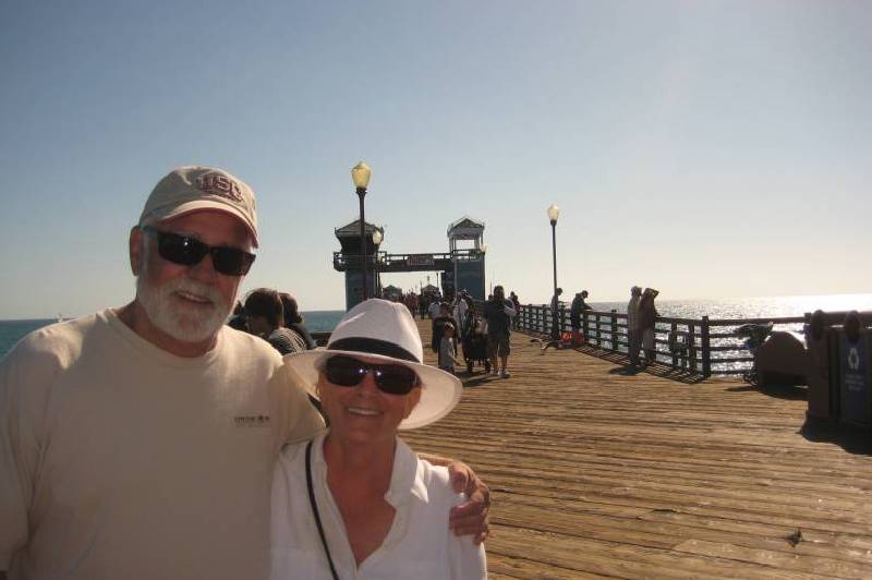 Couple smiling on sunny pier