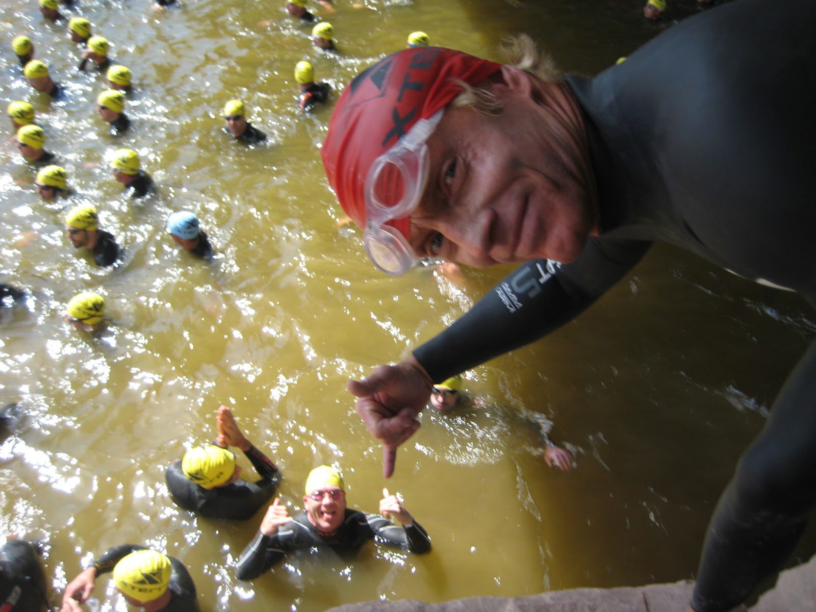 Man pointing at swimmers below bridge