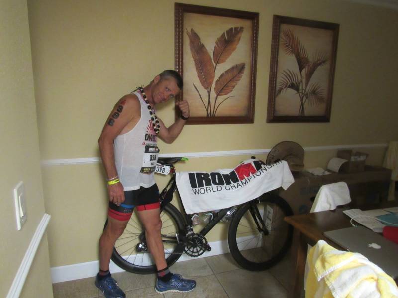 Man posing with Ironman race bike
